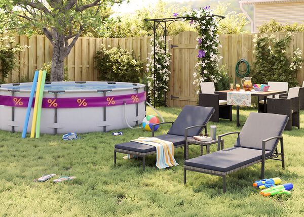 Sonniger Garten hinter dem Haus mit Aufstellpool, Poolnudeln, Schwimmbrille, Wasserball und Flip-Flops im Gras. Zwei schwarze Metall-Sonnenliegen mit grauen Auflagen stehen neben einem kleinen Beistelltisch, w&auml;hrend eine Outdoor-Essgruppe mit dunklen Geflechtsesseln bei einer bl&uuml;henden Pergola, einem Holzzaun und sommerlichen Gartenaccessoires platziert ist.