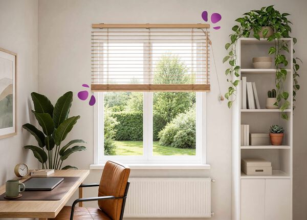 Eine helle Homeoffice-Ecke mit einer Holzjalousie an einem gro&szlig;en Fenster. Sie l&auml;sst weiches Tageslicht herein und rahmt den Blick auf einen gr&uuml;nen Garten. Darunter stehen ein Holzschreibtisch und ein Lederstuhl, dekoriert mit Laptop, Schreibwaren und einer Keramiktasse. Eine hohe Pflanze, offene Regale mit B&uuml;chern und kleinen Kakteen sowie eine Kleiderstange runden den ruhigen, aufger&auml;umten Arbeitsplatz ab.